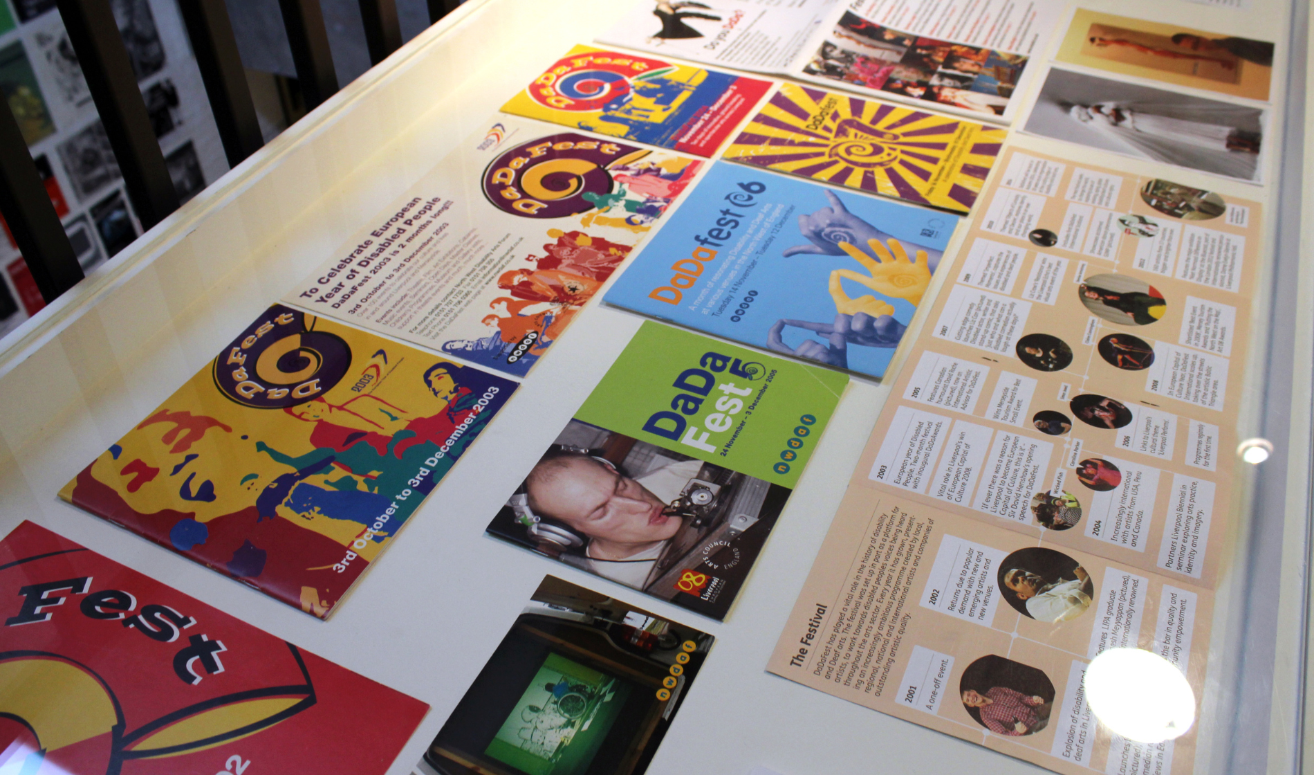 Archive programmes and images from DaDaFest laid out on a table